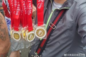 😂球迷在阿森纳冠军巡游卖奖牌,撕开贴纸写着:利物浦是冠军!配图